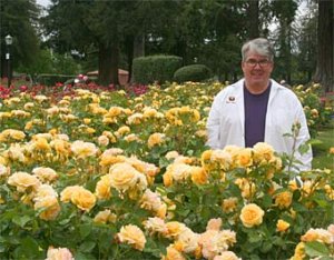 Tom Carruth standing among yellow roses