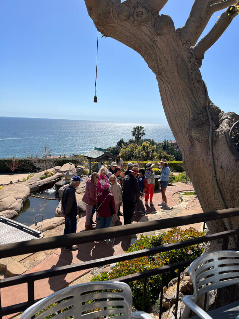 Members of the Malibu Garden Club with ocean views as a background